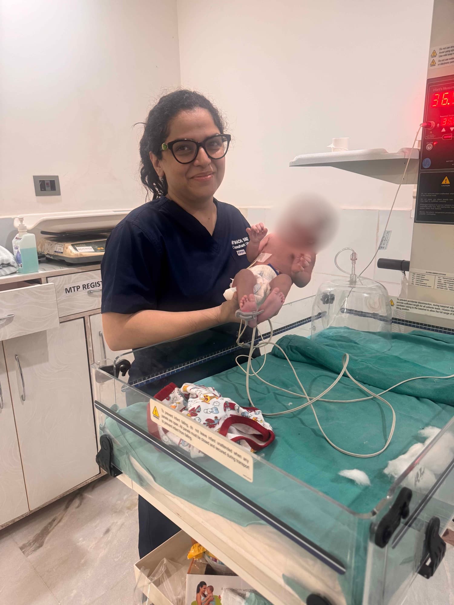 Dr. Shachi Singh checking on a newborn at the infant warmer after birth at Prakash Hospital Noida