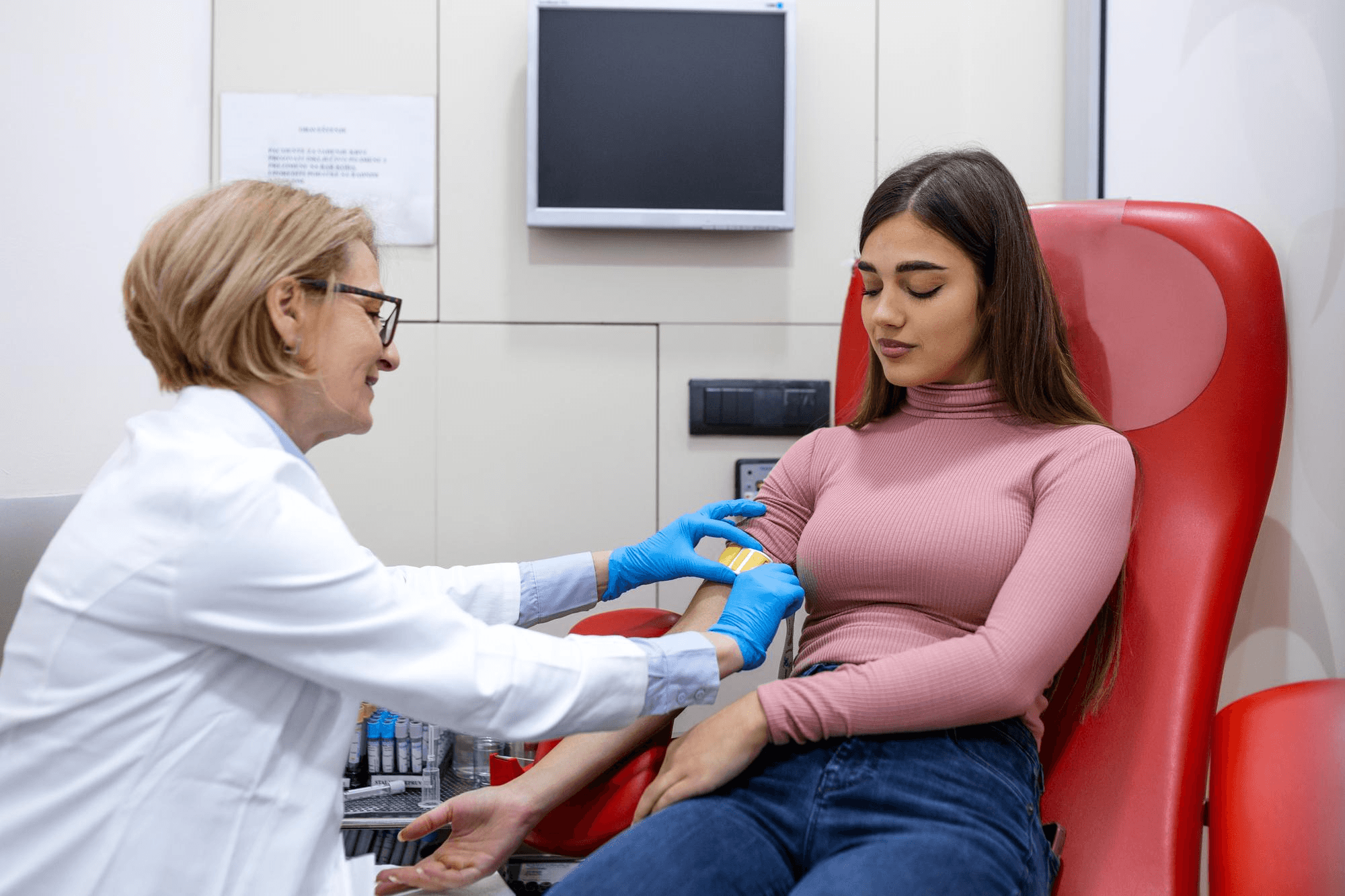 Gynecologist performing routine health check, blood test, illustrating recommended screening frequency for annual exams and periodic preventive tests for women.