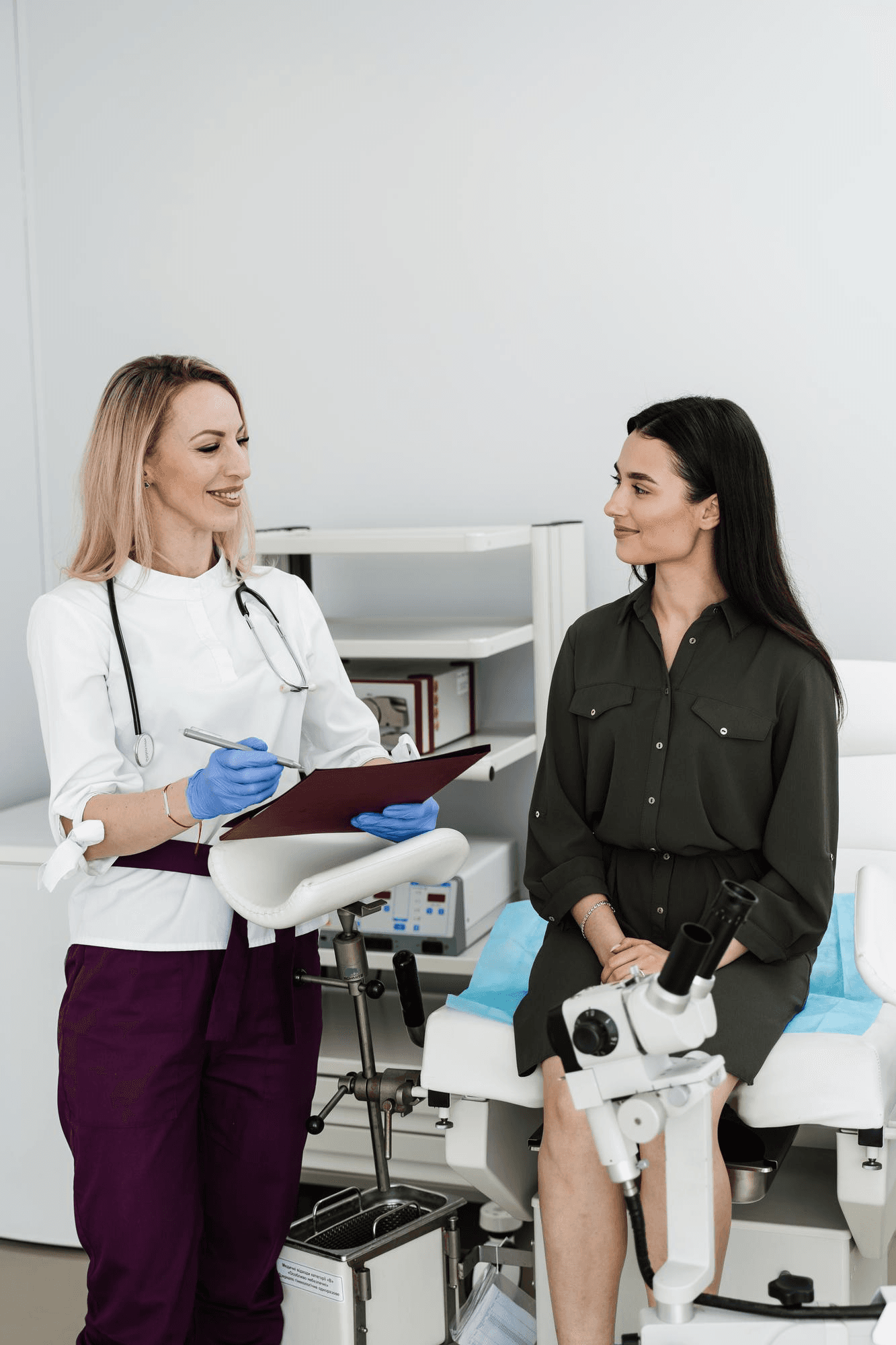 Gynecologist talks with patient after a colposcopy, going over the results and explaining what happens next.