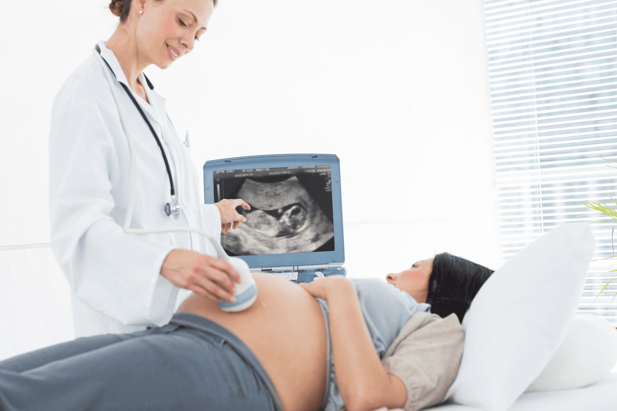 Health professional conducting an ultrasound while the mother observes the screen.