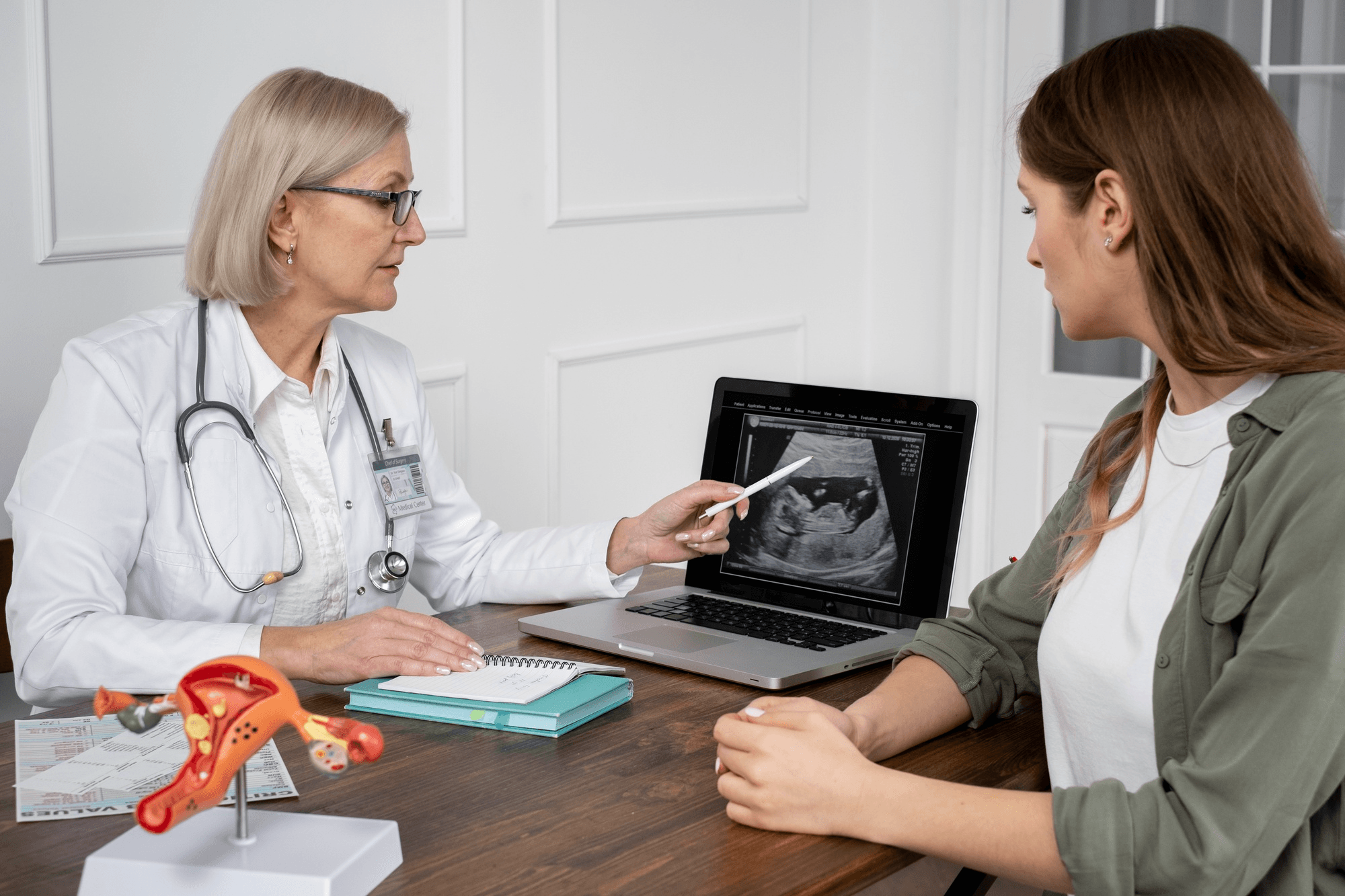 A woman talks to a gynecologist as they review an ultrasound report, emphasizing the importance of getting checked if periods stop or become irregular.