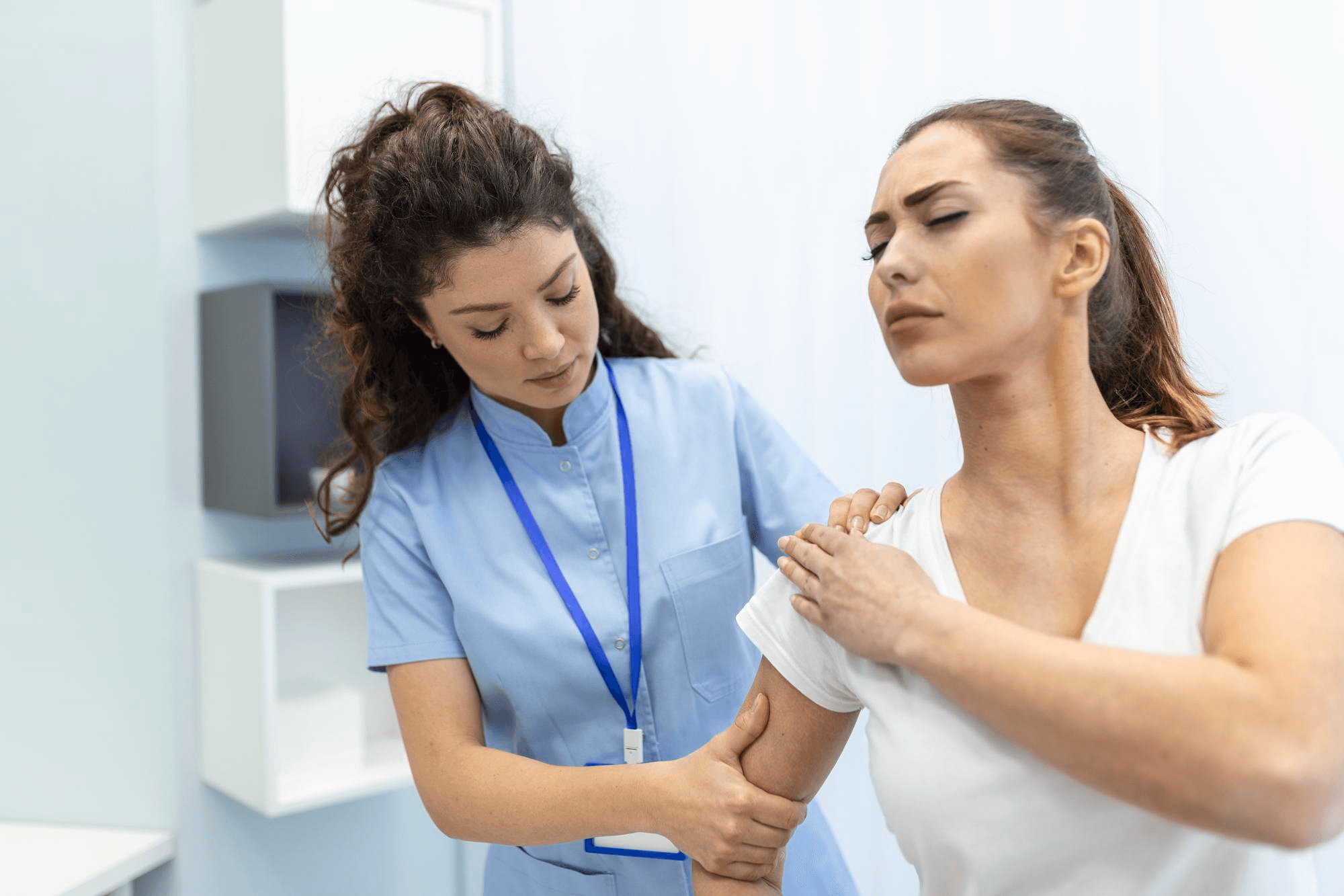A woman feels shoulder pain and bloating after laparoscopic surgery while a healthcare provider checks her arm during a follow-up visit.