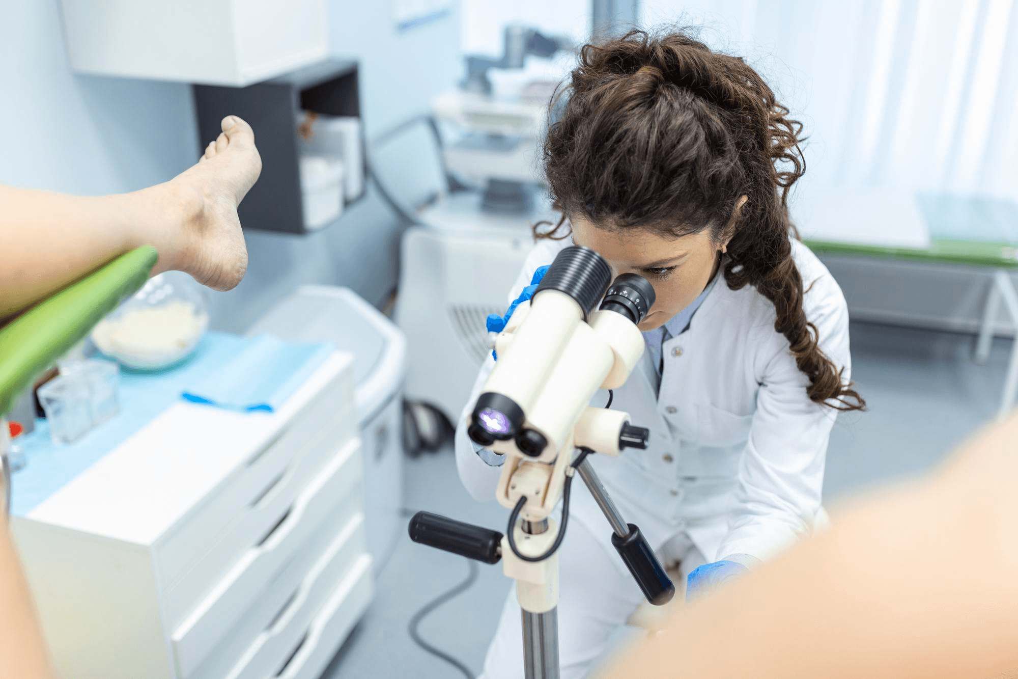 A gynecologist uses a speculum to collect a cervical cell sample for a Pap smear in the clinic.