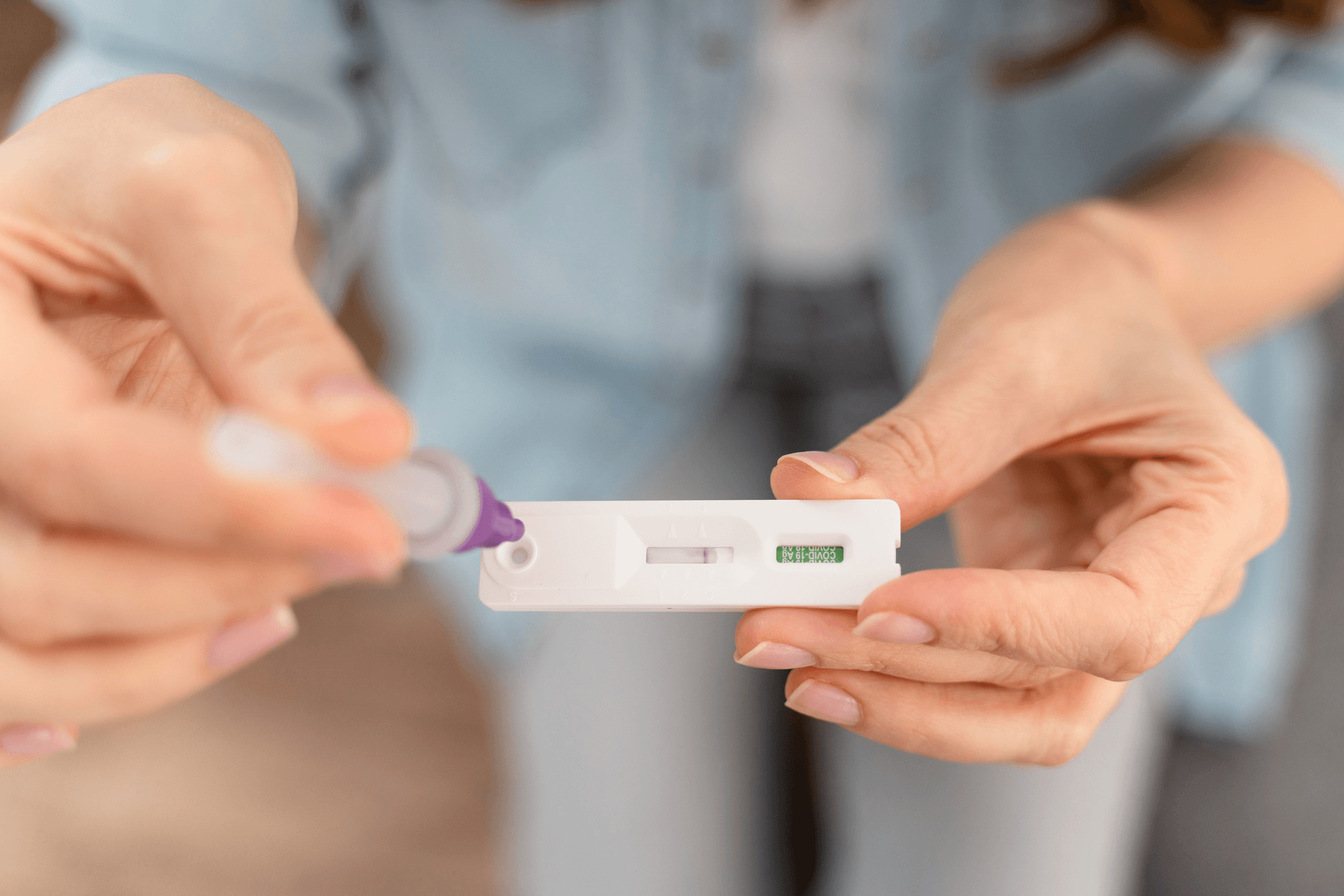 A woman holds an ovulation test kit, applying a sample, showing the step of checking fertile days during the menstrual cycle.