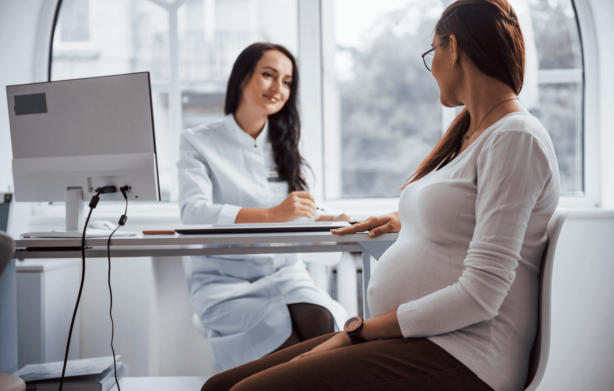 Pregnant woman visiting a doctor in a clinic to discuss her gestational diabetes during prenatal visits and consultations.