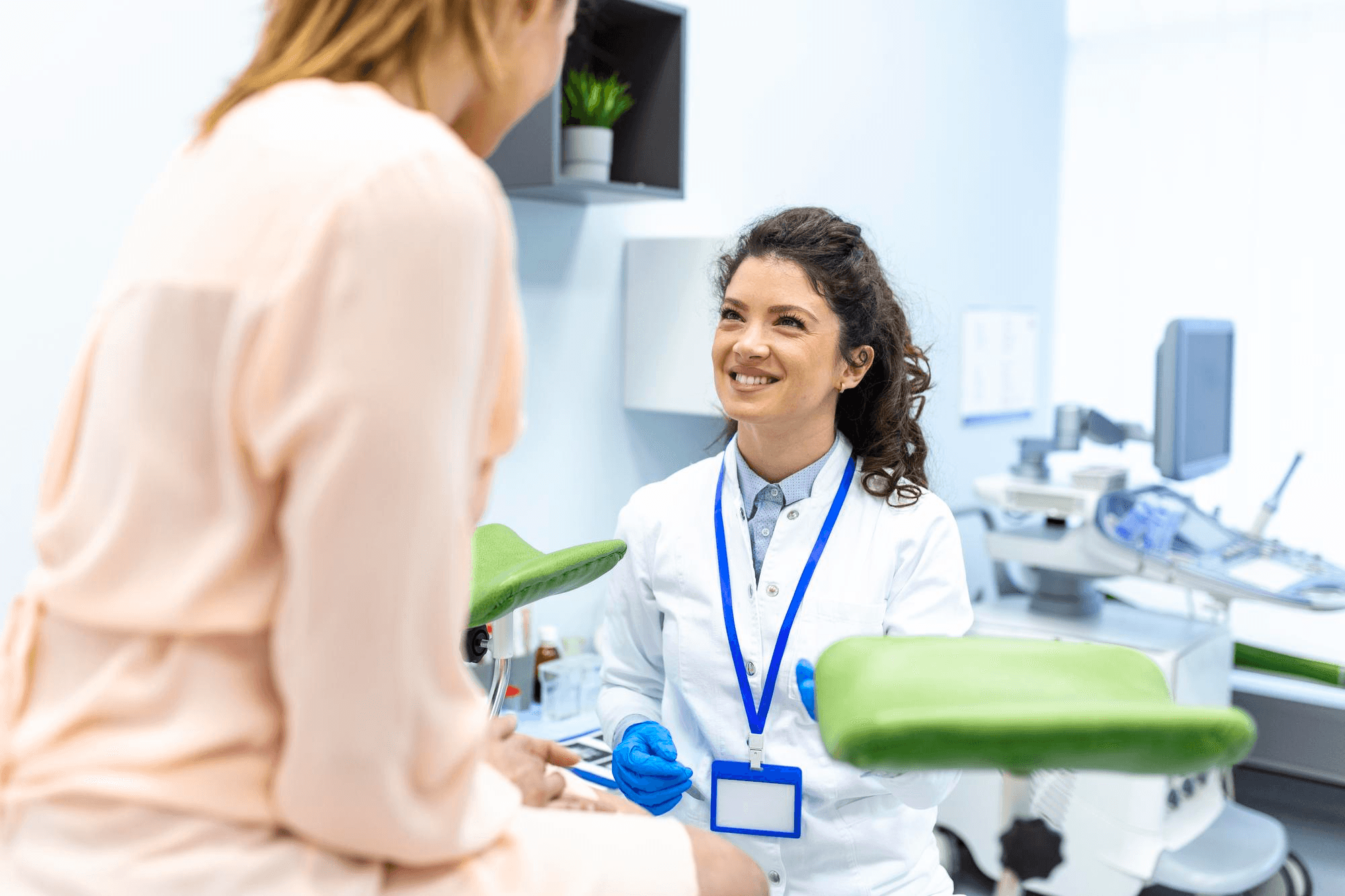A woman doctor has a private conversation with her female patient inside a clinic as they talk about health related issues.