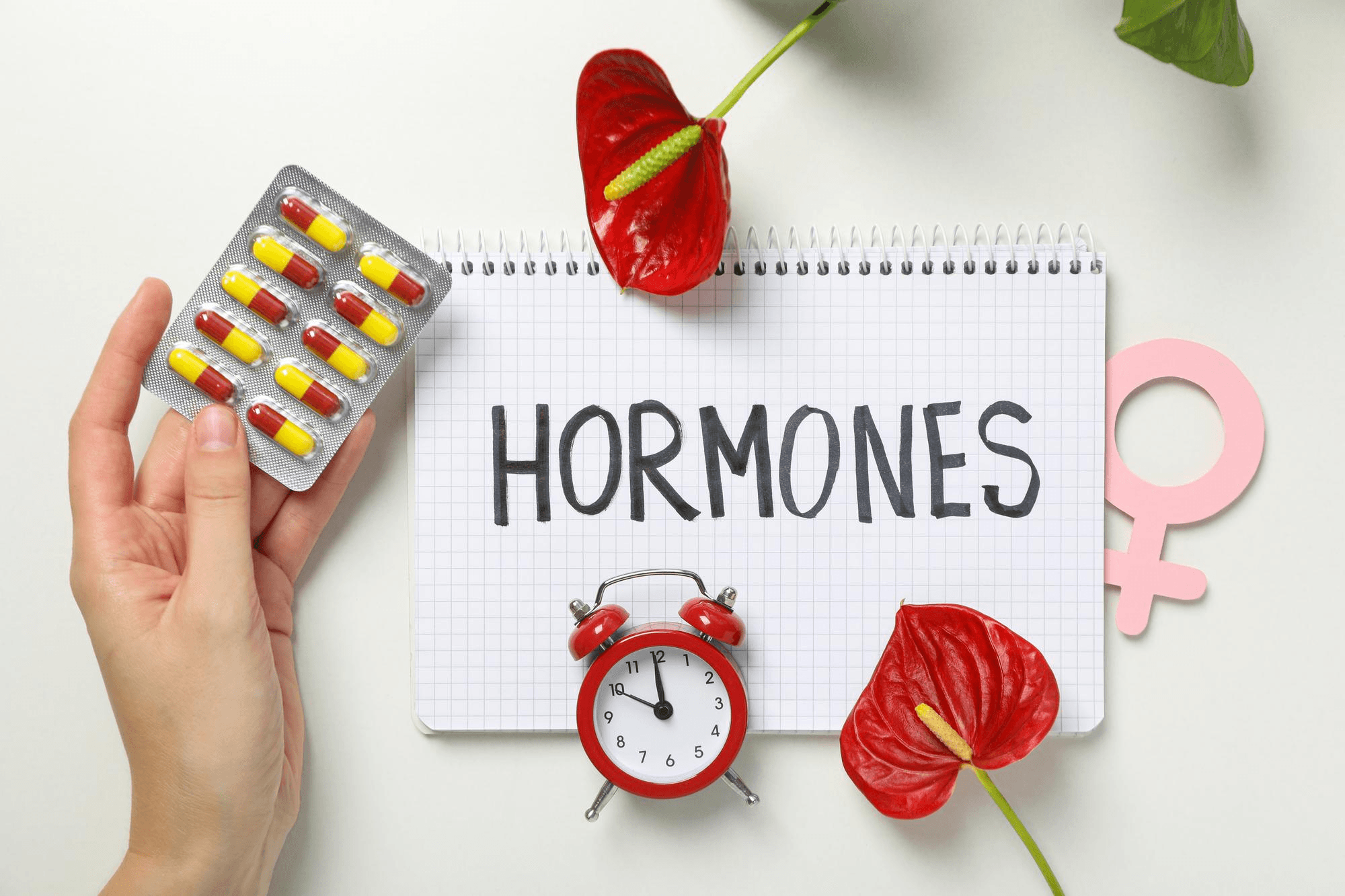 Hormonal imbalances and infertility represented by pills, clock, female symbol