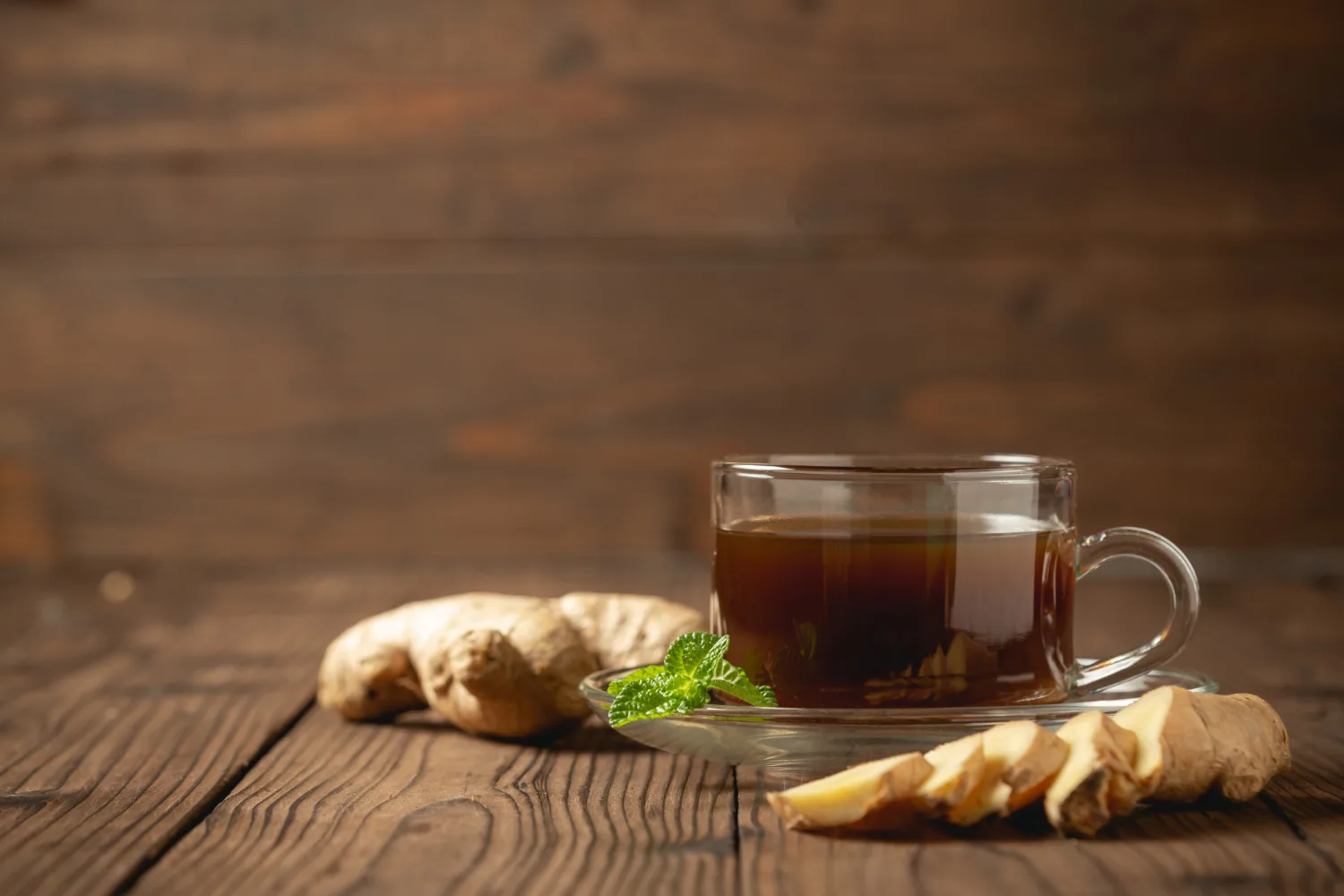 A cup of ginger tea with fresh ginger slices.