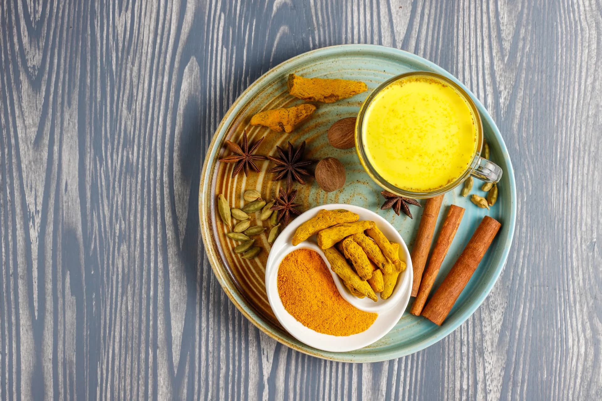 A display of vibrant spices including turmeric, cinnamon sticks and other colorful spices with health boosting properties.