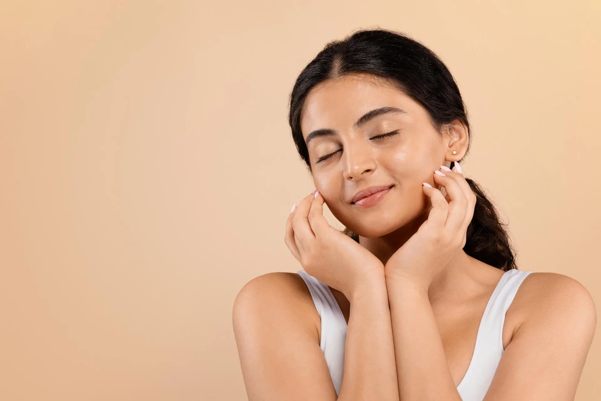 Pregnant woman admiring her naturally glowing complexion, representing one of the common and normal skin changes that occur during pregnancy.
