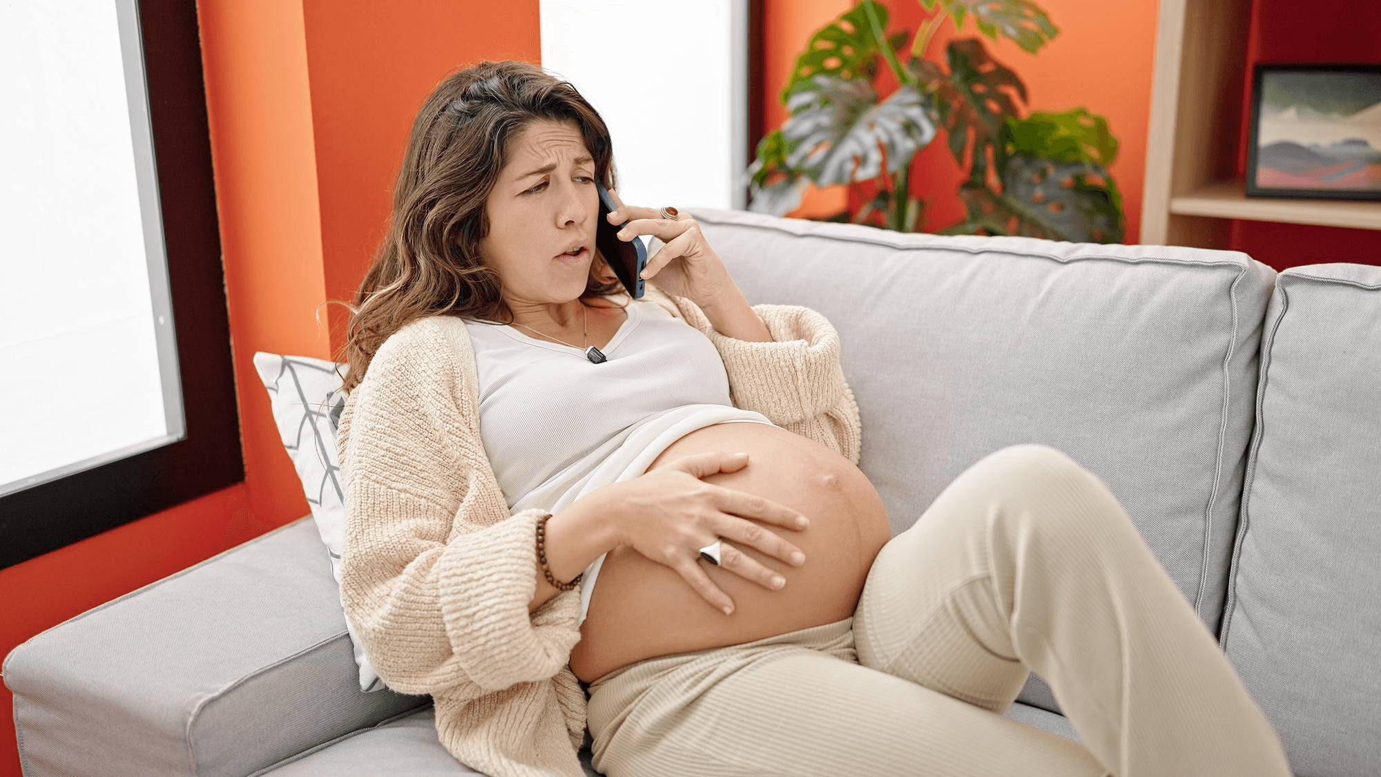Pregnant woman sitting on sofa.
