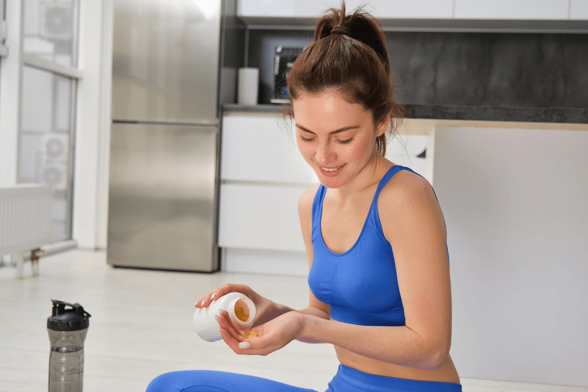 Pregnant woman following her prenatal supplement routine by taking a calcium tablet, highlighting the role of calcium in supporting a healthy pregnancy.